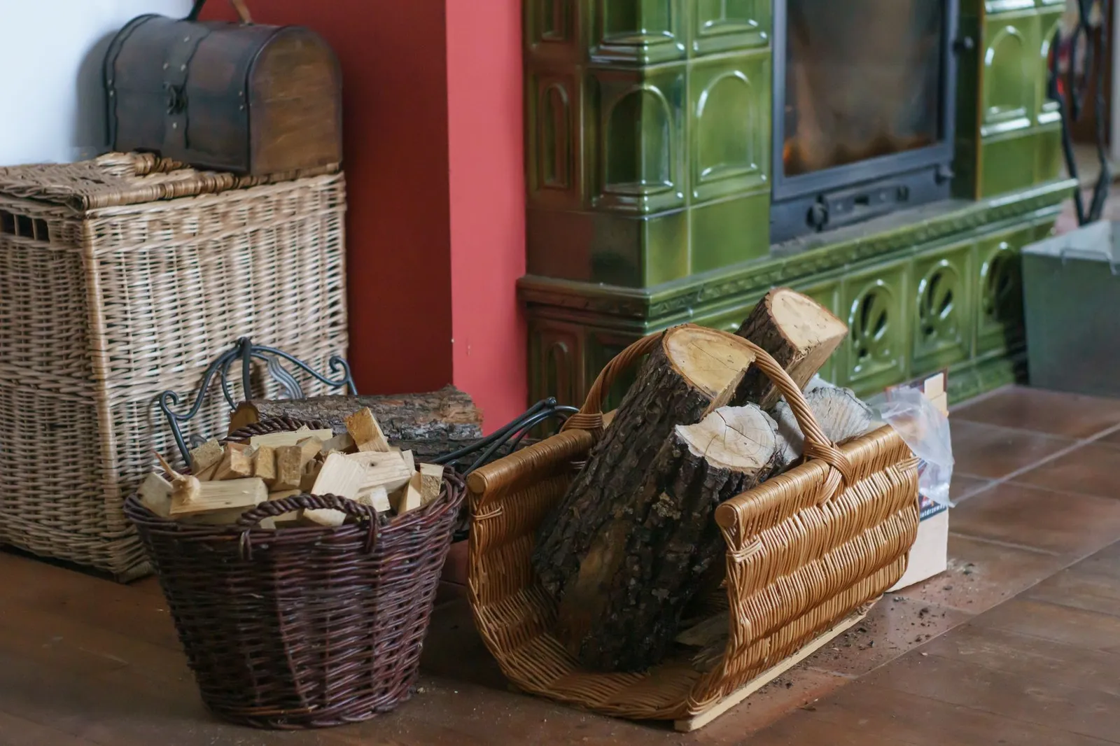 Paniers de bûches rentrés à l'intérieur près d'un poêle en faïence